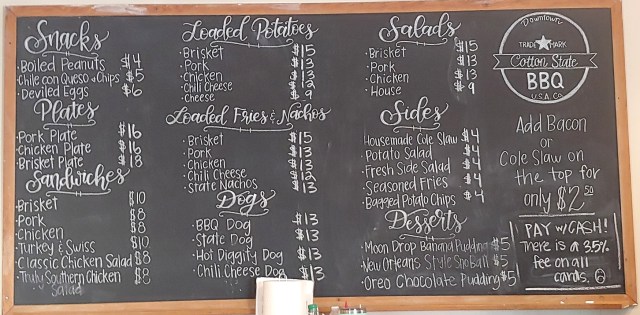 Cotton State BBQ chalkboard menu: Snacks, Plates, Sandwiches, Loaded Potatoes, Loaded Fries, Dogs, Salads, Sides, Desserts.
Add Bacon or Cole Slaw on top for $2.50.